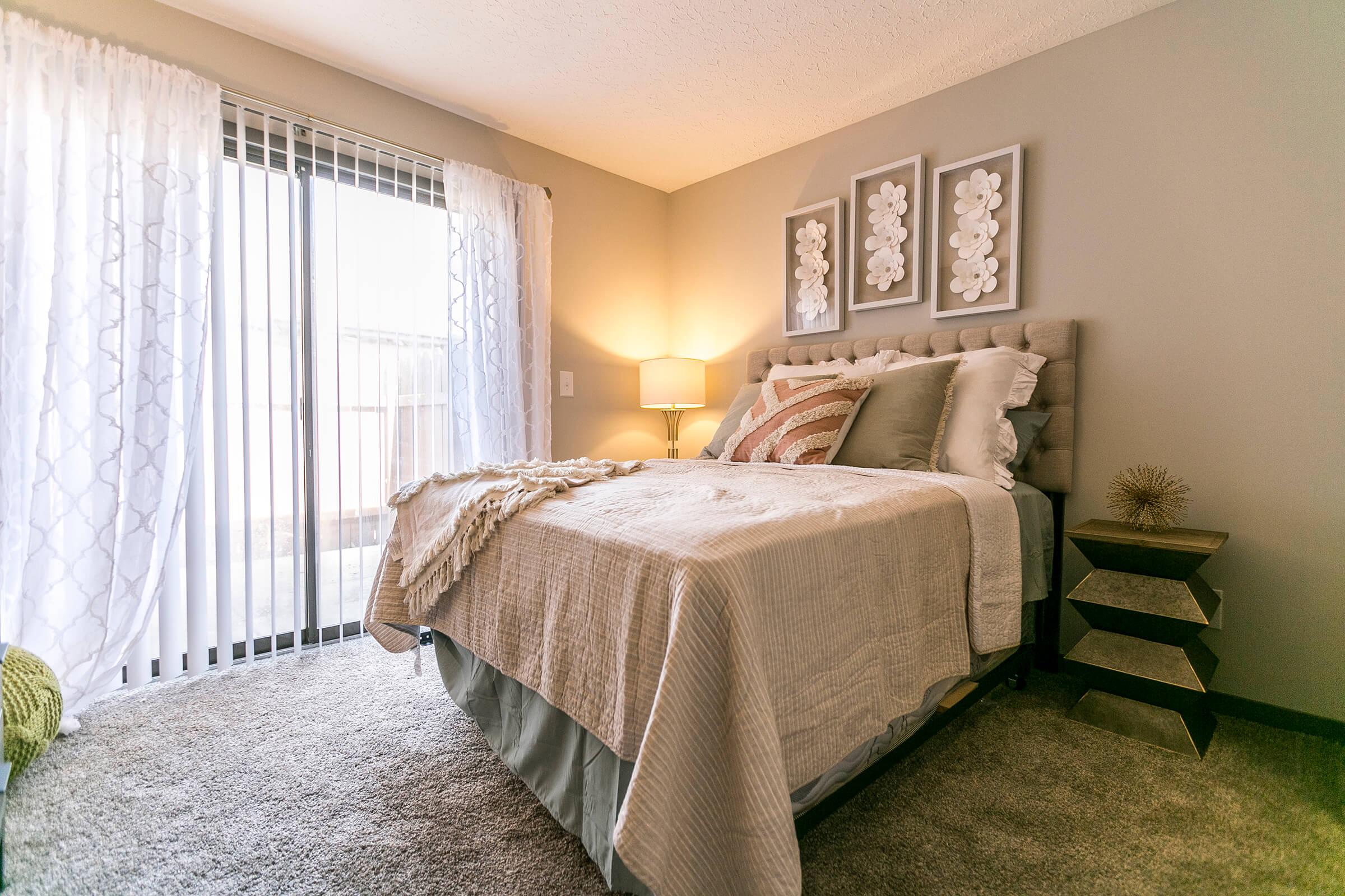 Bedroom with large bed and sliding glass doors.